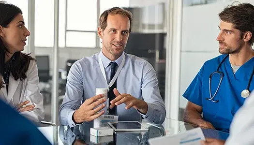 a man in a meeting speaks with doctors